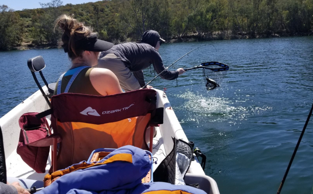 Power Queen 12V Lithium LiFePO4 Batteries supporting fishing boat on lake with two people and trees