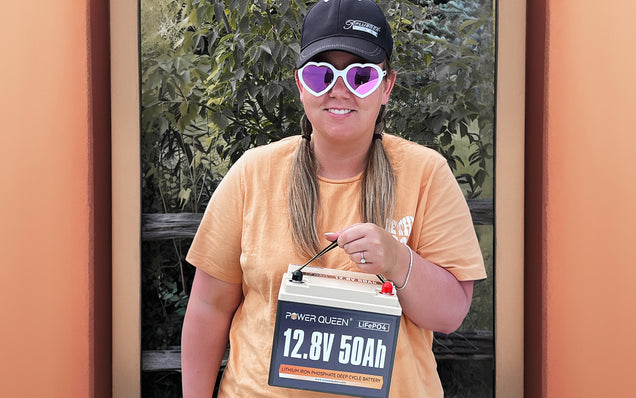Person holding a Power Queen lifepo4 deep cycle battery with a blurred background
