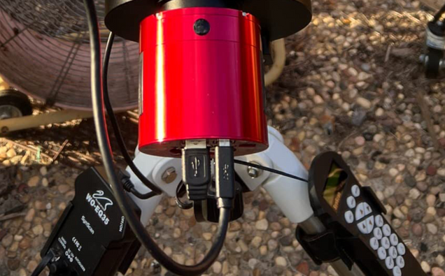 Close-up of a red mechanical component on a bicycle with a blurred background