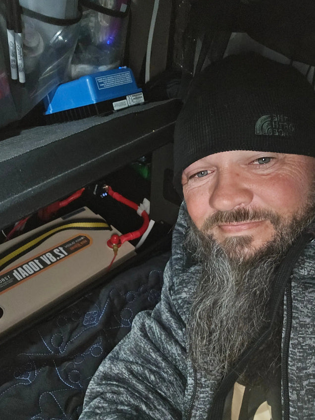 User showcasing a Power Queen 12.8V 100Ah LiFePO4 battery installed in his RV.