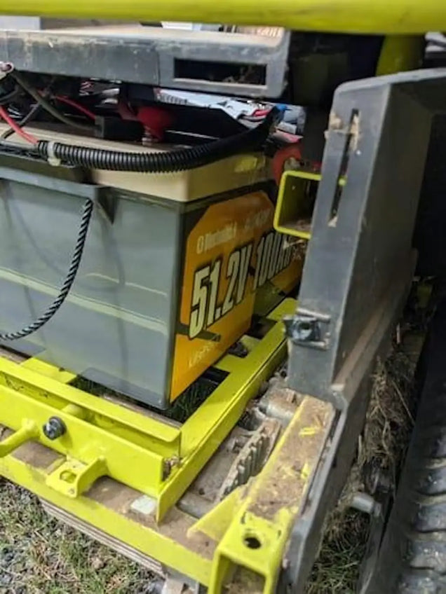 Power Queen 51.2V 100Ah lithium golf cart battery installed as a lead-acid replacement in a Ryobi Zero Turn mower.