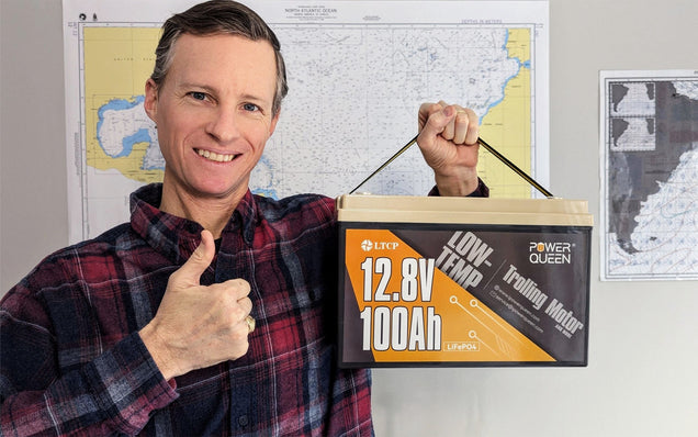 Man holding a Power Queen trolling motor battery box with maps in the background