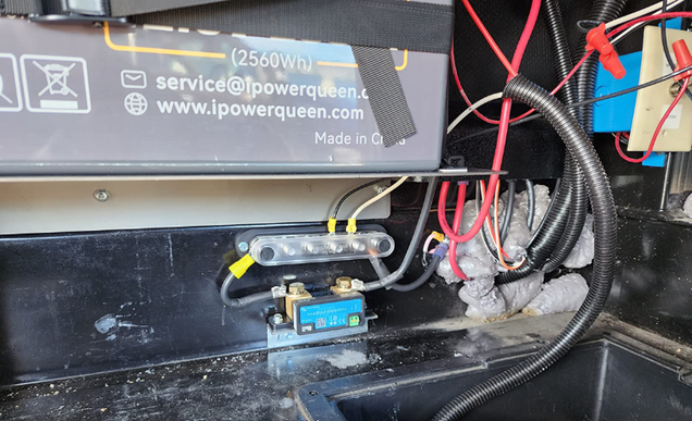 Close-up of a Power Queen lithium battery with visible branding and wiring.