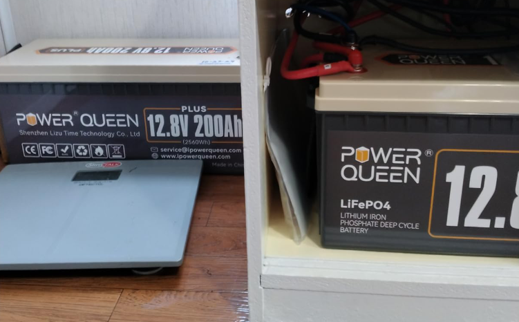 Power Queen 12v 200ah plus lifepo4 battery on a wooden floor