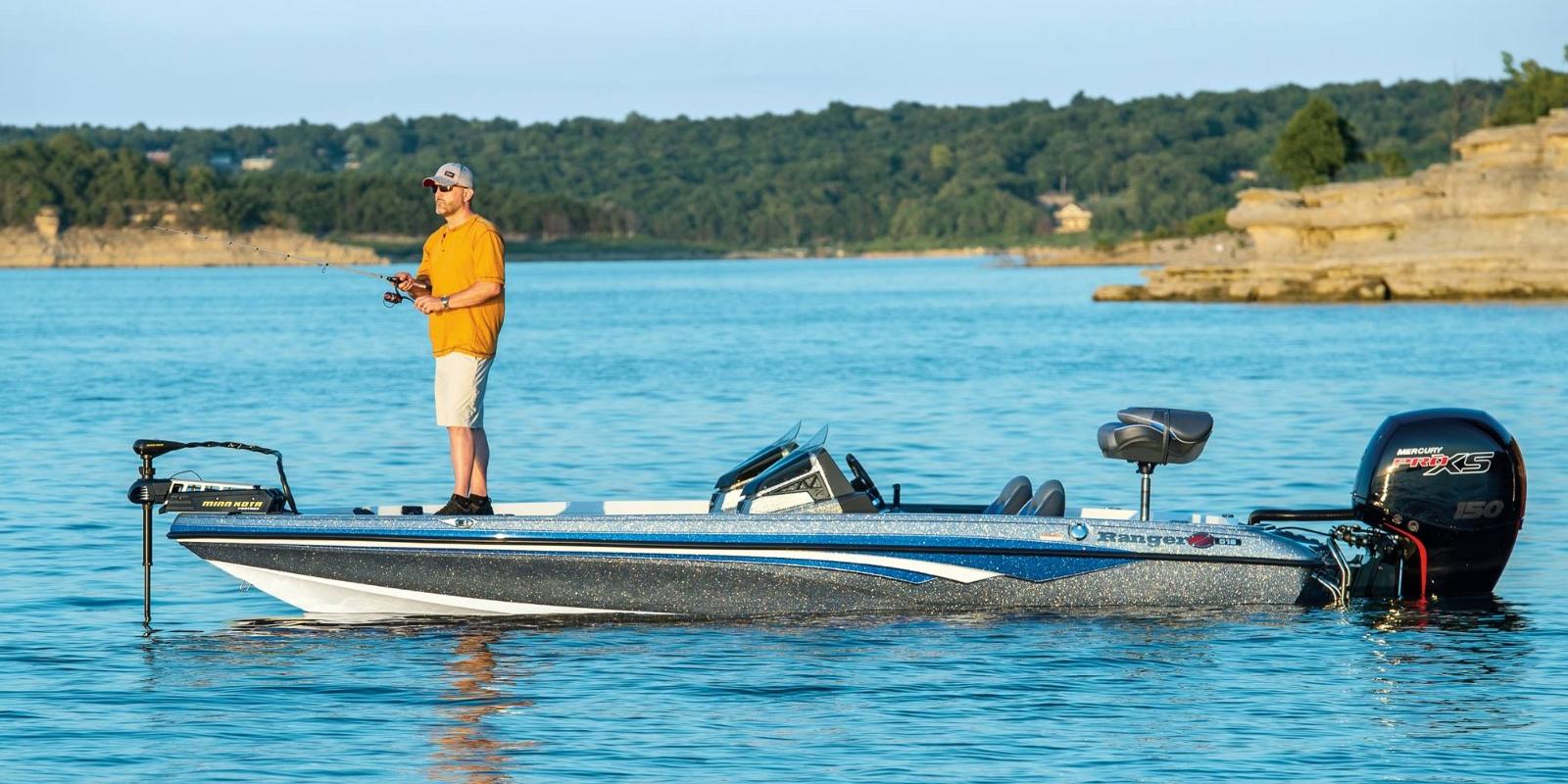 Man fishing from a boat on a calm lake with a scenic background