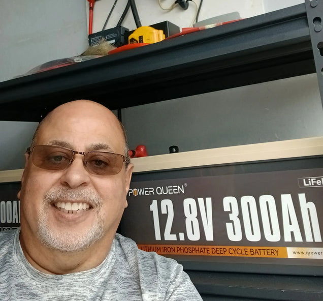 a man with gray t-short show his power queen battery for home backup power